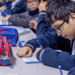 Un jóven escribiendo en una clase