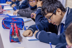 Un jóven escribiendo en una clase