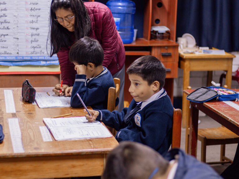 A teacher helping focused students